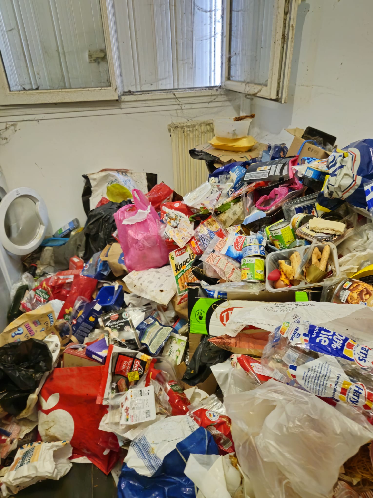 Pièce avec accumulation de déchets et cartons à évacuer en déchèterie professionnelle