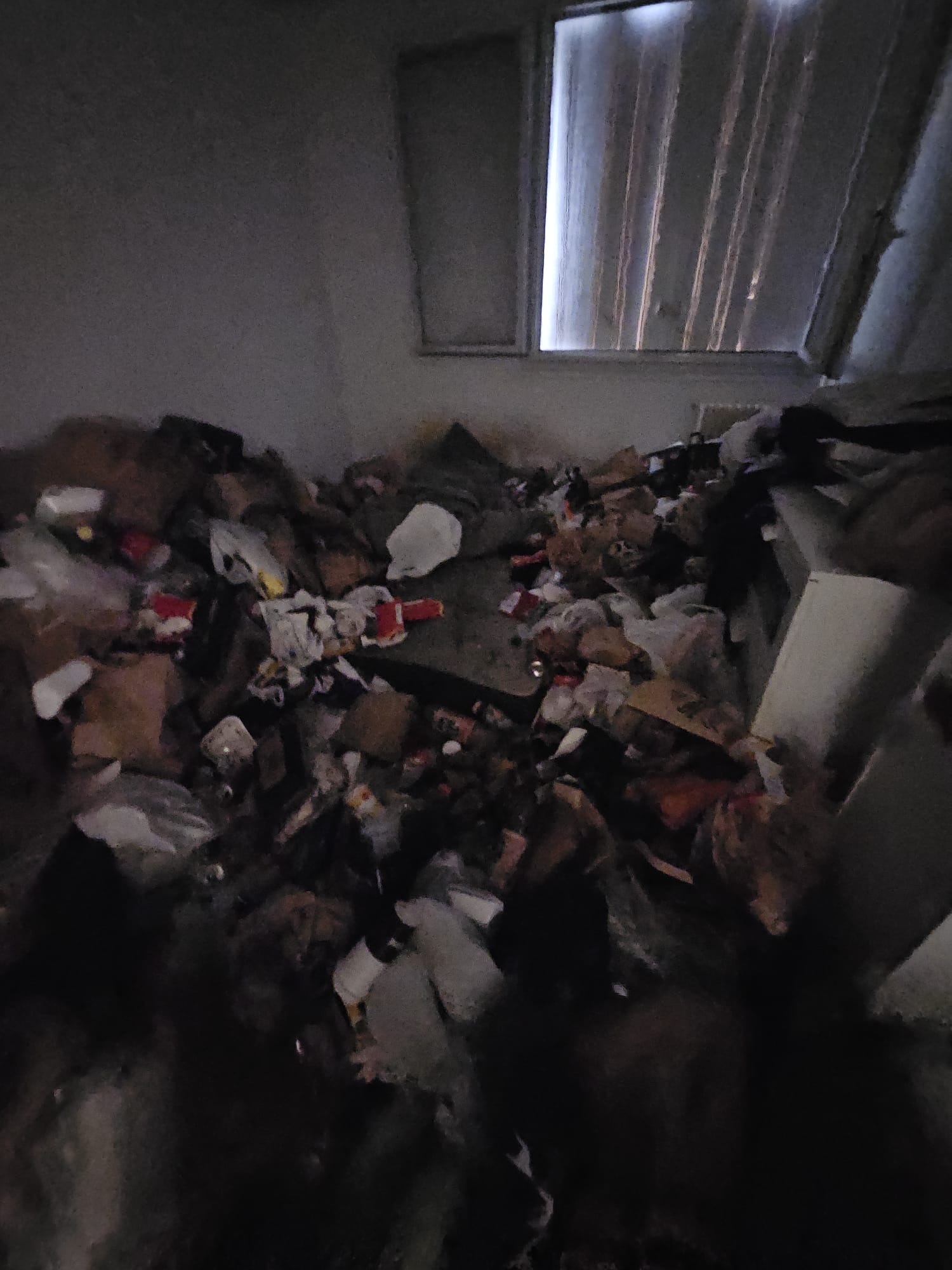 Pièce sombre avec accumulation hétéroclite à débarrasser
