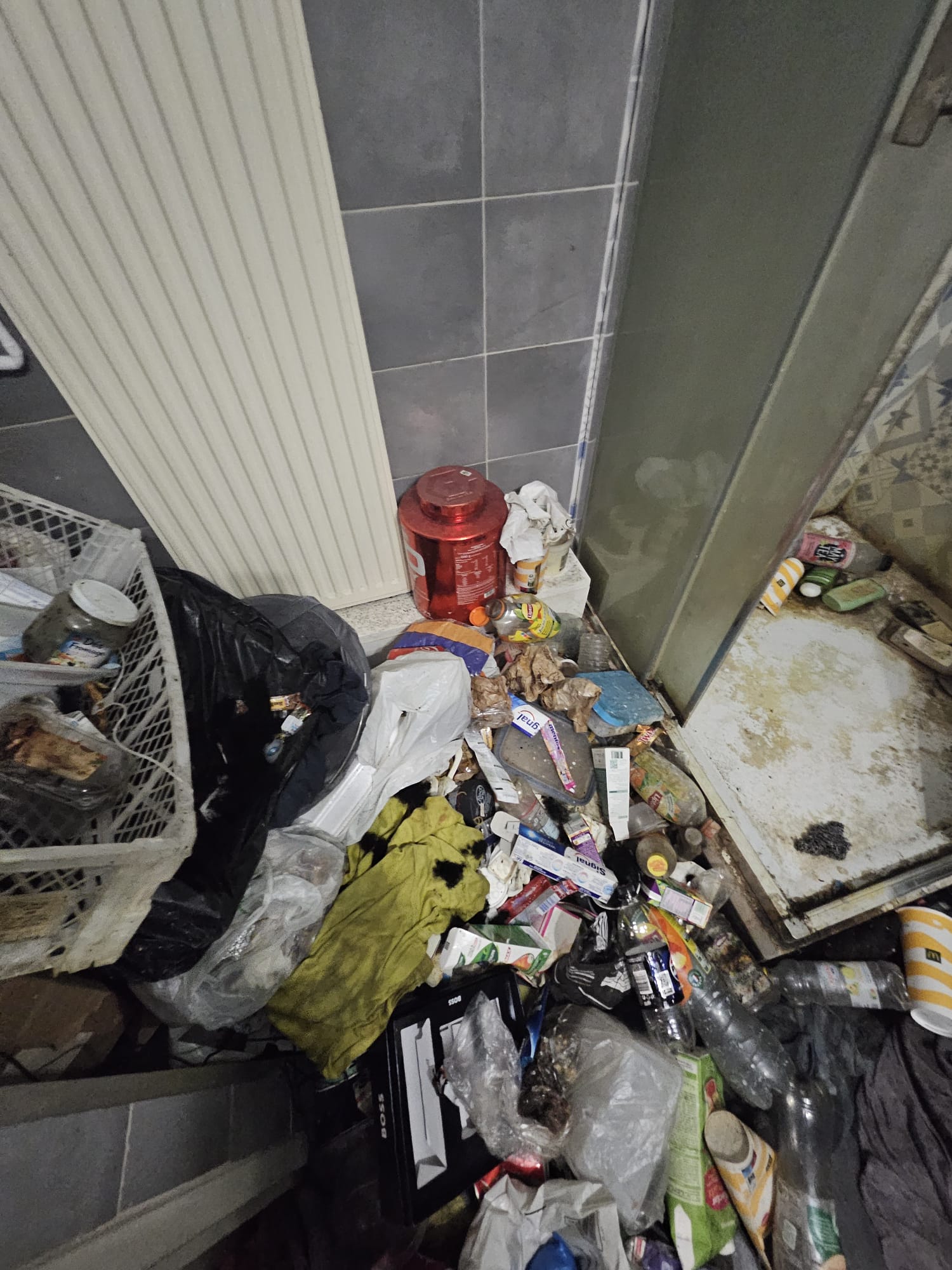 Salle de bains avec sol jonché de déchets à décontaminer